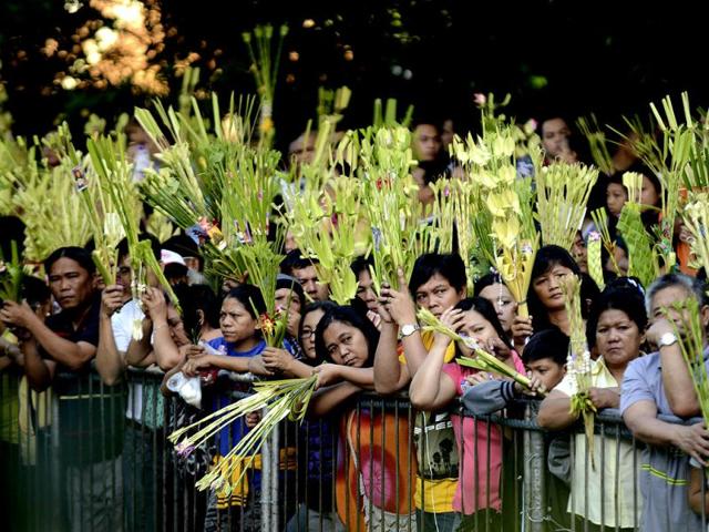 Roman Catholic dovetees wave their palm fronds during Palm Sunday mass in Manila. Palm Sunday marks the start of the lenten season and according to believers, Jesus Christ's triumphant entry into Jerusalem. AFP photo