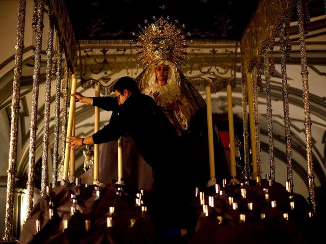 A member of the "Nuestro Senor Orando en el Huerto y Maria Santisima Consuelo de las Tristezas" brotherhood places a candle on a weighted structure with a statue of a Virgin, traditionally known as "paso", during the "fundicion de velas" (smelting of candles) on the eve of Holy Week at Los Descalzos church in Ronda, near Malaga, southern Spain. Reuters photo