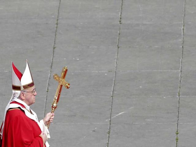 Pope Francis walks with his papal cross during the Palm Sunday mass at Saint Peter's Square at the Vatican. Reuters