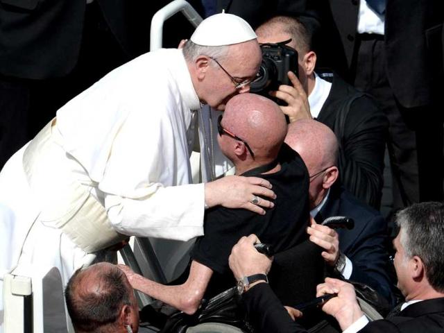 Pope Francis blesses a disabled person from the papamobile after mass on St Peter's square on Palm Sunday at the Vatican. AFP