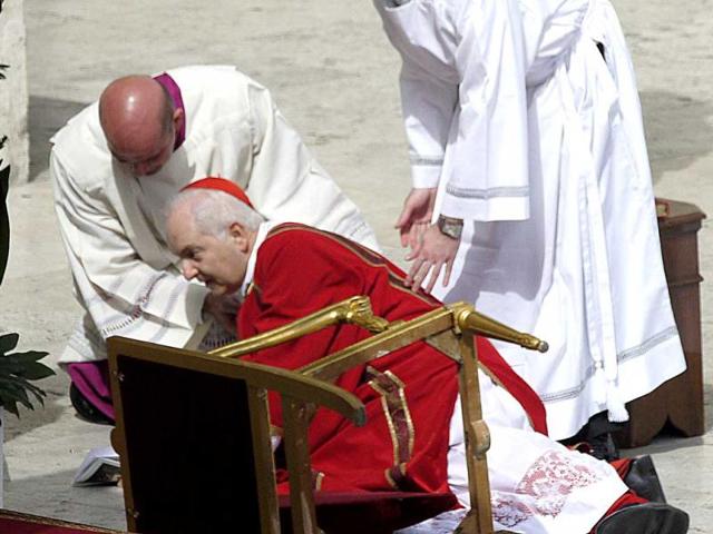 Italian cardinal Mauro Piacenza is helped up after he fell near the Pope during a papal mass at St Peter's Square on Palm Sunday at the Vatican. AFP