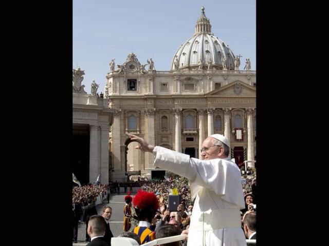 Pope Francis waves at a cheering crowd as he wades through St. Peter's Square at the Vatican on Palm Sunday. AP