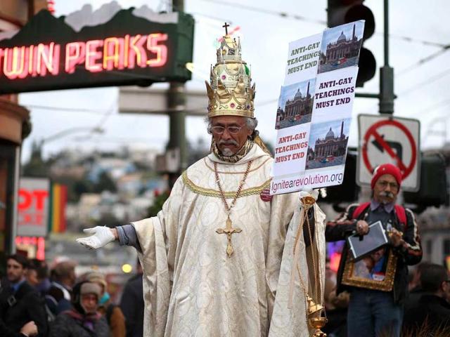 A same-sex marriage supporter dressed as the pope holds a sign during a rally in support of marriage equality in San Francisco, California. AFP