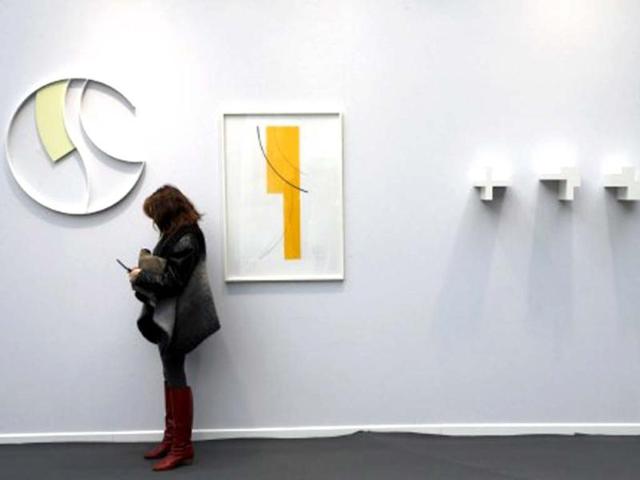 A visitor stands beside an artwork by Swiss artist Gottfried Honegger during the opening of the "Art Paris Art Fair" at the Grand Palais in Paris. AFP