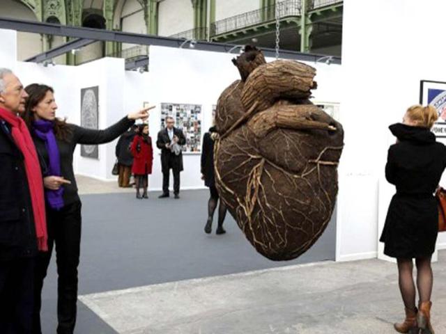 Visitors look at an artwork by Russian artist Dimitri Tsykalov displayed during the opening of the 'Art Paris Art Fair' at the Grand Palais in Paris. AFP