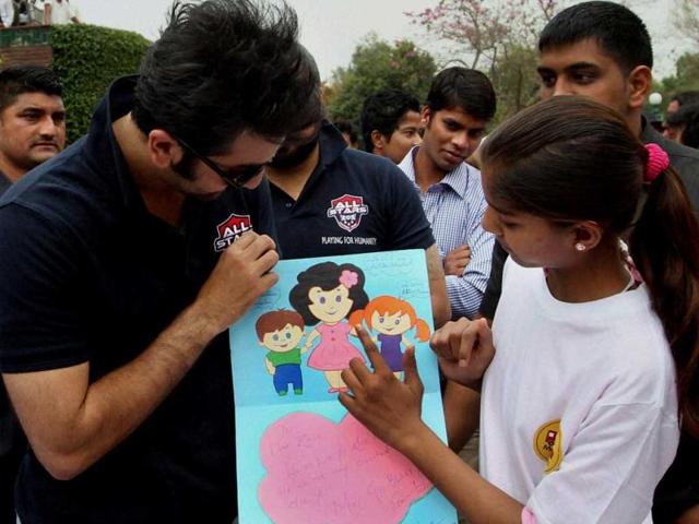 Ranbir Kapoor receives a painting during a charity football match in New Delhi on Thursday. PTI Photo