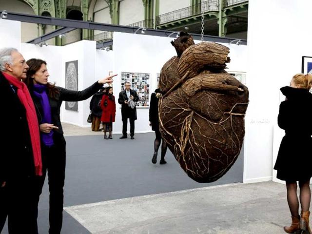 Visitors look at an artwork (C) by Russian artist Dimitri Tsykalov displayed during the opening of the "Art Paris Art Fair" at the Grand Palais in Paris. (AFP Photo)