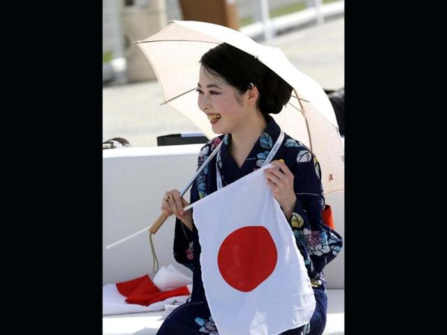 A Japanese woman, sporting her country's national flag, arrives at the Meydan race track before the start of the Dubai World Cup. (AFP)