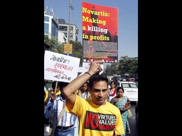 File-photo-of-an-Indian-activist-from-a-health-group-holds-a-placard-while-participating-in-a-protest-against-Swiss-drugmaker-Novartis-AG-outside-their-office-in-Mumbai-AP-Photo File-photo-of-an-Indian-activist-from-a-health-group-holds-a-placard-while-participating-in-a-protest-against-Swiss-drugmaker-Novartis-AG-outside-their-office-in-Mumbai-AP-Photo