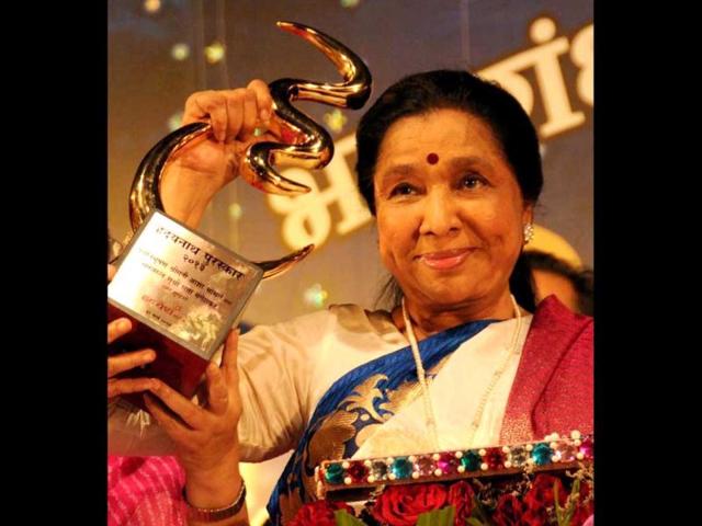 Singer Asha Bhosle holds up her statuette after being felicitated in Mumbai on Sunday night. (PTI Photo) Singer Asha Bhosle holds up her statuette after being felicitated in Mumbai on Sunday night. (PTI Photo)