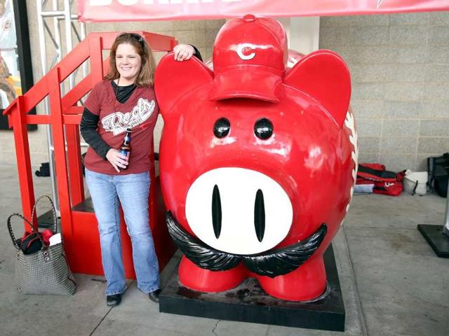 Amy Venable poses with a large piggy bank before the start of the Los Angeles Angels of Anaheim game against the Cincinnati Reds at Great American Ball Park in Cincinnati, Ohio. AFP