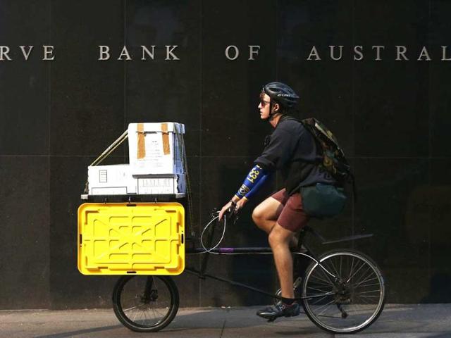 A worker on his bike rides past the Reserve Bank of Australia building in central Sydney. Reuters