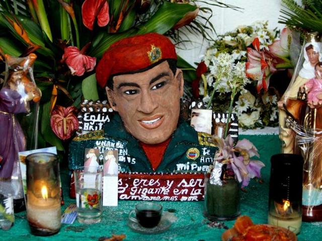 A bust of late Venezuela's President Hugo Chavez is adorned with flowers, candles and religious images inside a people's shrine built in his honor at the "23 de Enero" or "23rd of January" slum in Caracas, Venezuela. AP photo