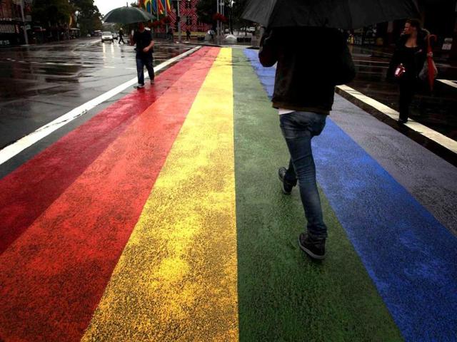 People walk across a rainbow pedestrian crossing painted on Sydney's Oxford street, the city's main gay district. Officials have ordered the removal of the rainbow pedestrian crossing painted on a street in Sydney's main gay district, setting off a fierce debate. Reuters