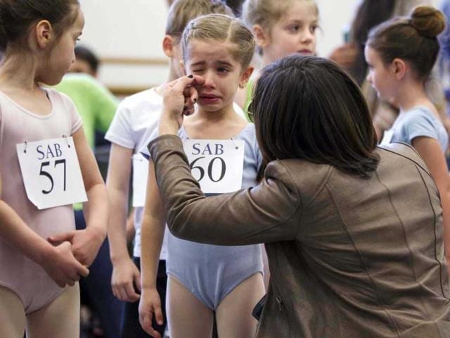 The mother of young ballet dancer Kyra Neamonitakis wipes a tear from her eyes before sending her into auditions for six-year-olds at the School of American Ballet (SAB) at Lincoln Center in New York. Reuters