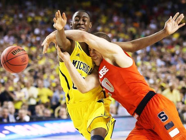 Brandon Triche of the Syracuse Orange loses the ball as he drives in the second half against Caris LeVert of the Michigan Wolverines during the 2013 NCAA Men's Final Four Semifinal at the Georgia Dome in Atlanta, Georgia. AFP