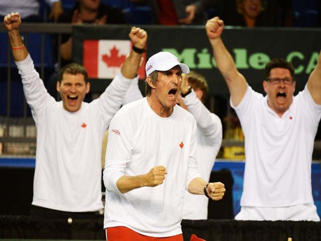 Canada's team captain, Martin Laurendeau (C) celebrates his team, Daniel Nestor and Vasek Pospisil, winning over the Italians Fabio Fognini and Daniele Bracciali at the Davis Cup World Group's doubles rubber at the Doug Mitchell Thunderbird Sports Centre, in Vancouver, Canada. AFP