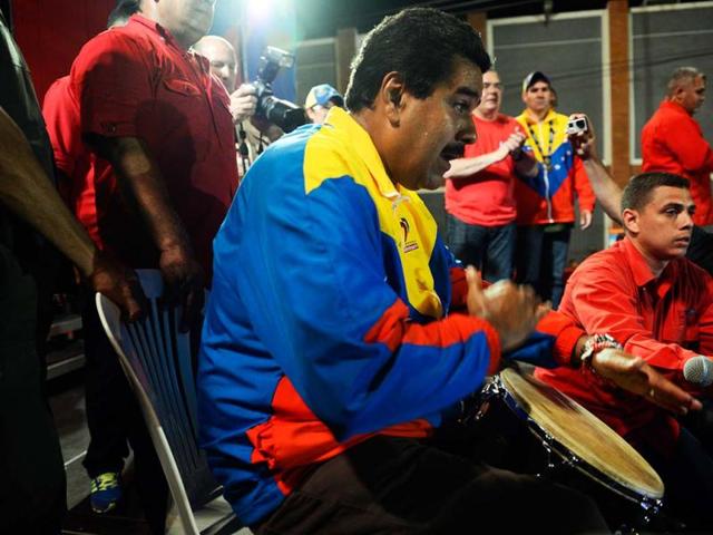 Venezuelan acting President Nicolas Maduro plays a musical instrument during a campaign rally in Puerto Ordaz, Bolivar state, Venezuela. AFP
