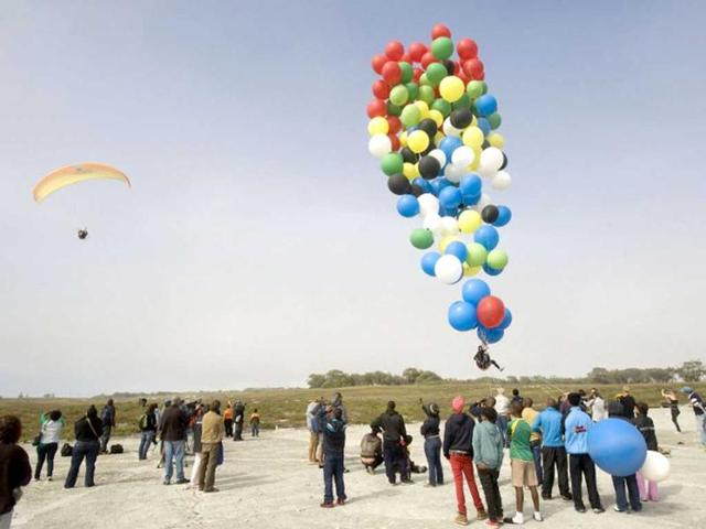 Matt Silver-Vallance gets ready prior to flew across the sea from Nelson Mandela's apartheid island prison using helium-filled giant party balloons in Cape Town. AFP