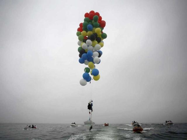 South Africa's Matt Silver-Vallance floats above the sea using helium filled balloons from the airfield of Robben Island across the Atlantic Ocean in Cape Town. Reuters