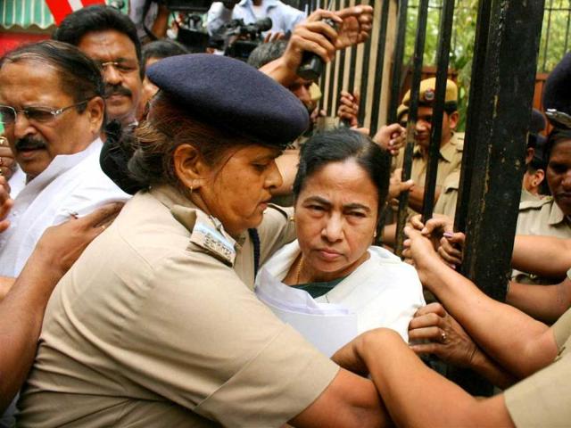 Security women protect West Bengal chief minister Mamata Banerjee during a protest by SFI activists on her arrival at Yojana Bhavan in New Delhi. SFI activists were protesting over the death of SFI member Sudipto Gupta. PTI