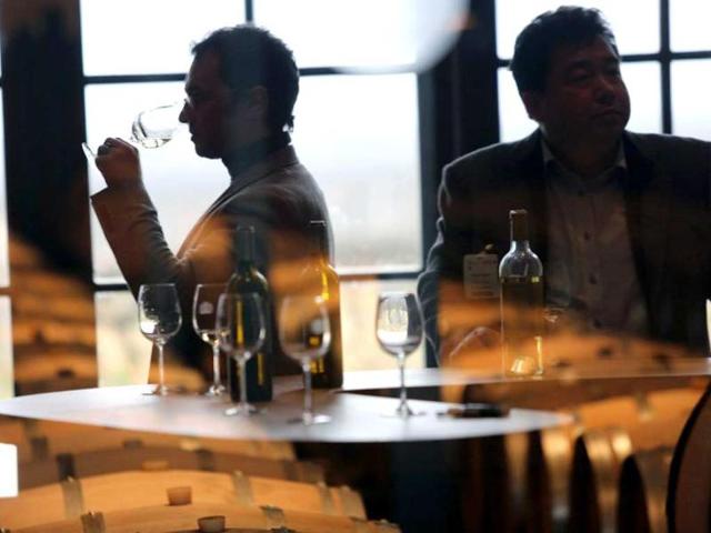 Two men taste the new 2012 Chateau Rayne-Vigneau Bordeaux vintage wine in Sauternes on the first day of the annual "Bordeaux primeur wines week". AFP