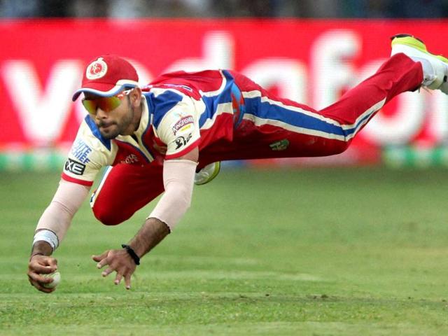 Royal Challengers Bangalore's Virat Kohli dives to stop the ball during T20 match against Kolkata Knight Riders at Chinnaswamy Stadium in Bengalore. (PTI)
