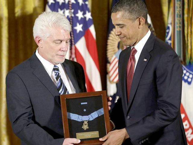 President Barack Obama, (R), stands with Ray Kapaun, (L), nephew of Chaplain Capt. Emil J Kapaun, US Army, as he awards the Medal of Honor posthumously to Chaplain Kapaun in the East Room of the White House in Washington. (AP Photo)