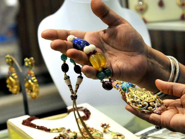 Visitors at an exhibitor's stall during the Gem and Jewellery Fair in New Delhi. HT Photo/Vipin Kumar