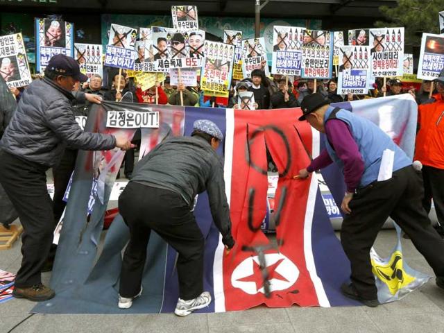 South Korean protesters deface a North Korean flag at an anti-North Korea protest on the birthday of late leader Kim Il Sung in Seoul, South Korea. The sign on the flag reads " Kim Jong Un Out." (AP)