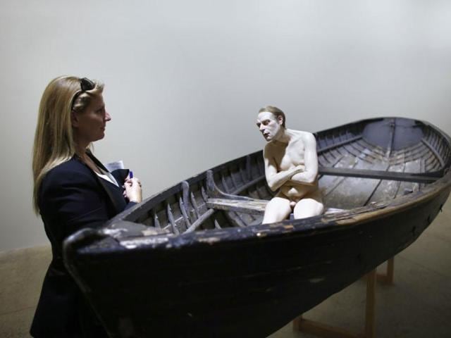 A visitor looks at Man In A Boat, a sculpture by Australian artist Ron Mueck exhibited at the Fondation Cartier pour l’art contemporain in Paris. (AFP Photo)