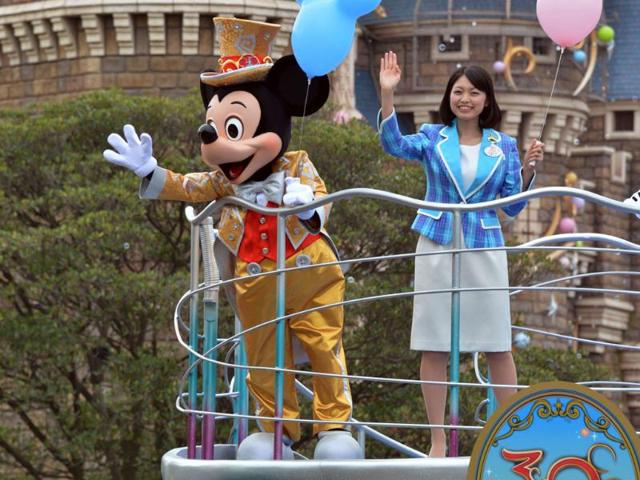 Mickey Mouse and Disney Resort Disney ambassador Ayaka Nagai wave their hands from a float for the parade as the Tokyo Disneyland celebrates its 30th anniversary in Tokyo. AFP