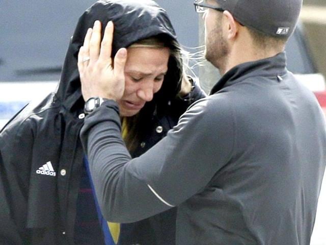 A Boston Marathon runner is comforted as she cries in the aftermath of two blasts which exploded near the finish line of the Boston Marathon in Boston. AP Photo