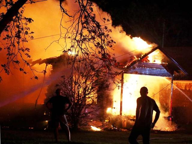 A person looks on as emergency workers fight a house fire after a near by fertilizer plant exploded in West, Texas. (AP)