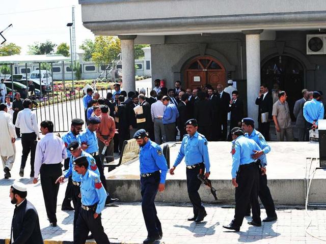 Pakistani lawyers and policemen gather at the high court building after the case hearing of former military ruler Pervez Musharraf in Islamabad. A Pakistani court ordered the arrest of former military ruler Pervez Musharraf. AFP