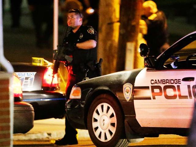 Police officers stand ready at a crime scene in Watertown, Massachusetts. A tense night of police activity that left a university officer dead on campus just days after the Boston Marathon bombings and amid a hunt for two suspects caused officers to converge on a neighborhood outside Boston, where residents heard gunfire and explosions.(AP)