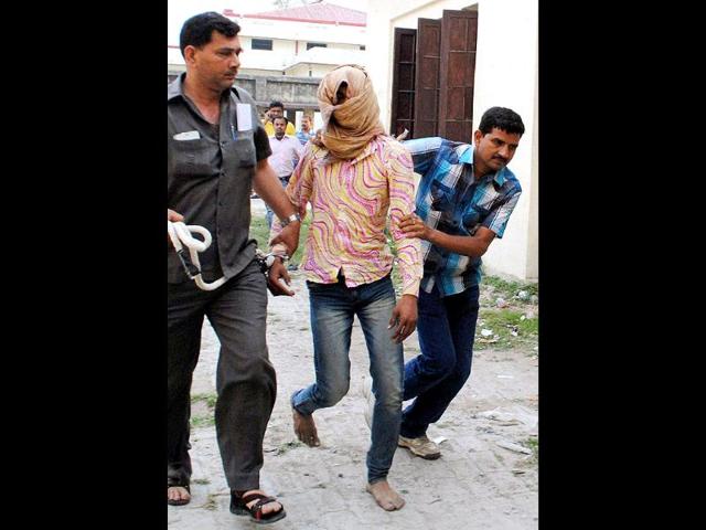 Delhi Police personnel take away Manoj Kumar, accused of brutally raping a five-year-old girl in the capital, in Muzaffarpur in Bihar. PTI Photo