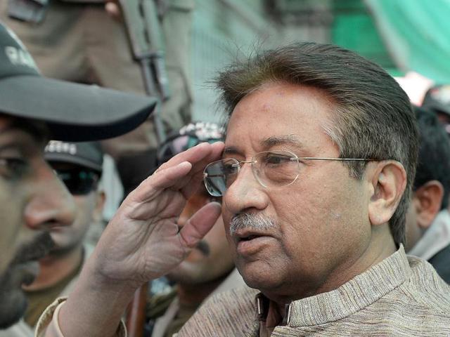 Former Pakistani president Pervez Musharraf is escorted by soldiers as he salutes on his arrival at an anti-terrorism court in Islamabad. (AFP)
