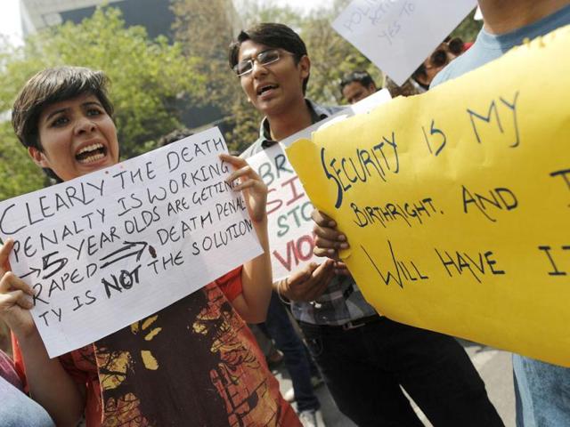 Demonstrators hold placards as they shout slogans during a protest outside police headquarters in New Delhi. Reuters