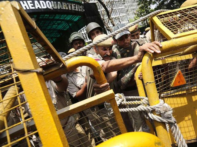 Police try to stop protesters from crossing over a barricade during a protest outside police headquarters against the rape of a five year old. Reuters