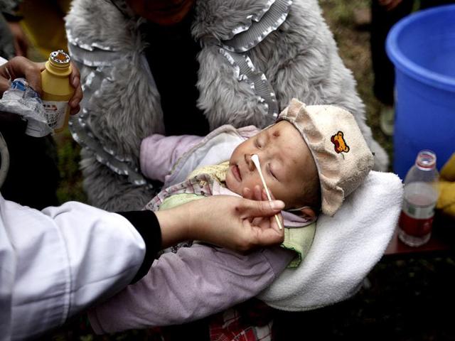 A three-month-old baby, whose mother was killed in a strong 6.6 magnitude earthquake, receives treatment at a medical point in Lushan county of Ya'an, Sichuan province in China. Reuters