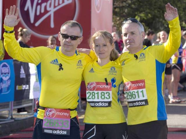 Craig Smith, left, Trisha Bunn and Keith Luxon, Brits who ran in the Boston marathon, shows their support in this year's Virgin London Marathon, at the Green Start Line, in Greenwich Park, east London. AP Photo