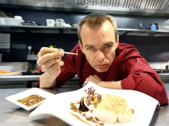 French Michelin-starred Chef David Faure holds worms as he poses in front of a dish "Cremeux de mais, foie gras poele" in the kitchen of his restaurant "Aphrodite", in Nice, southeastern France. Chef David Faure proposed dishes composed with worms and crickets. (AFP)