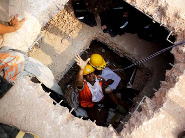 Fire fighters try to rescue garment workers, who are trapped inside the rubble of the collapsed Rana Plaza building, in Savar, 30 km (19 miles) outside Dhaka. Reuters/Andrew Biraj