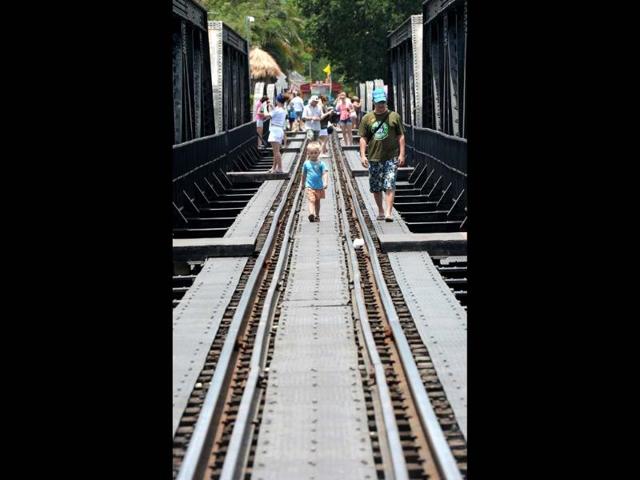 Foreign tourists walk on a railway bridge over river Kwai built during World War II in Kanchanaburi province. An elegant cemetery in strife-torn southeast Myanmar has long stood as a lonely testament to the fate of thousands of prisoners of war who died building Japan's "Death Railway". (AFP)