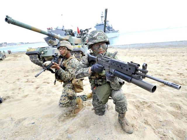 South Korean (R) and US (L) Marines take a position on the seashore during a joint landing operation by US and South Korean Marines in Pohang, 270 kms southeast of Seoul. The US and South Korea staged a military landing exercise as the Korean peninsula was already engulfed in a cycle of escalating tensions triggered by the North Korea's nuclear test in February. AFP PHOTO