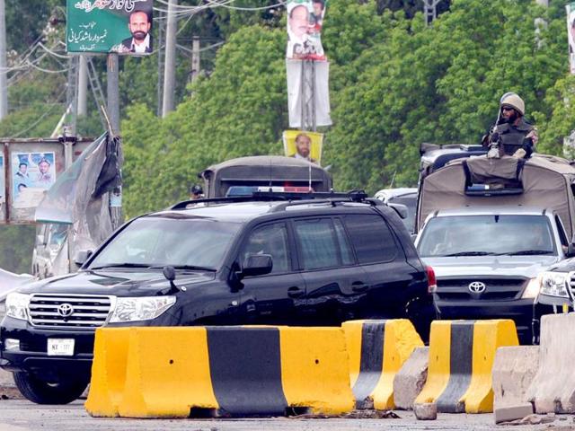 Pakistani paramilitary soldiers escort a black vehicle (L), carrying former Pakistani President Pervez Musharraf, as he returns to his residence declared a sub jail after he appeared at an anti-terrorism court in Islamabad. AFP PHOTO