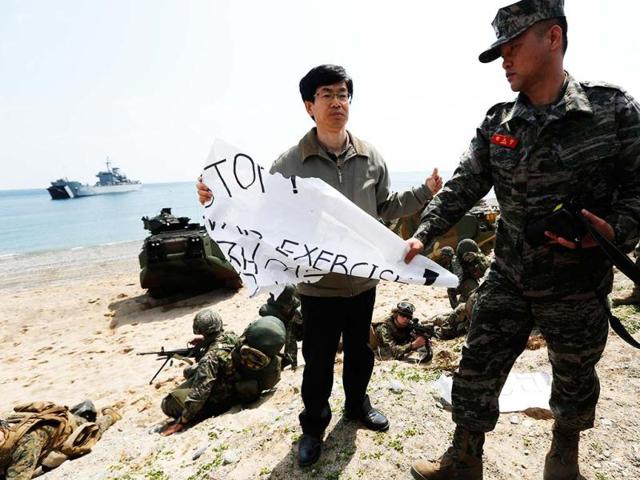 A South Korean marine takes away the banner which reads "Stop War Exercise" from an anti-war protester during the US-South Korea joint military exercises called Ssangyong 2013 as part of their two-month-long Foal Eagle military exercises in Pohang, south of Seoul, South Korea. AP Photo