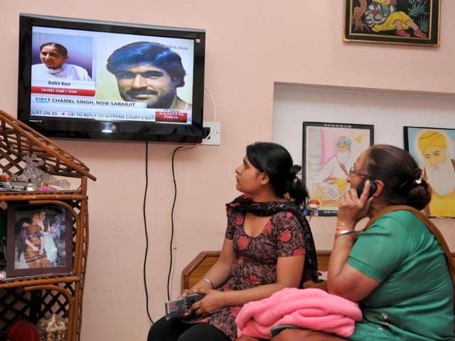 Sarabjit Singh's daughter Swapandeep Kaur and sister Dalbir Kaur looking at news on TV at their residence in Jalandhar. HT/Pardeep Pandit