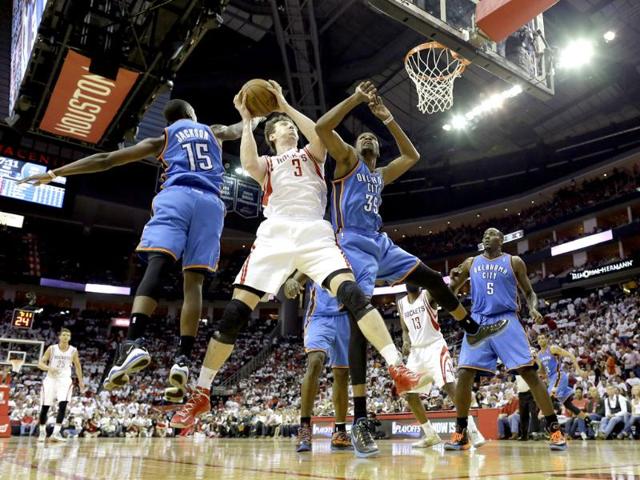 Houston Rockets' Omer Asik goes up for a shot as Oklahoma City Thunder's Reggie Jackson and Kevin Durant defend during the third quarter of Game 3 in a first-round NBA basketball playoff series in Houston. AP